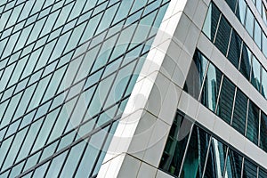 Fragment of a modern office building. Abstract geometric background. Part of a skyscraper with glass windows.