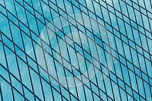 Fragment of a modern office building. Abstract geometric background. Part of a skyscraper with glass windows.