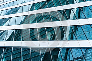 Fragment of a modern office building. Abstract geometric background. Part of a skyscraper with glass windows.