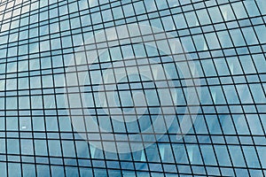 Fragment of a modern office building. Abstract geometric background. Part of a skyscraper with glass windows.