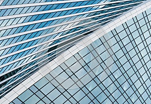 Fragment of a modern office building. Abstract geometric background. Part of a skyscraper with glass windows.