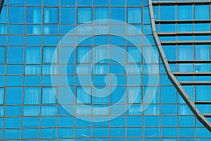 Fragment of a modern office building. Abstract geometric background. Part of a skyscraper with glass windows.