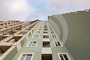 Fragment of a modern residential building bottom-up view against a cloudy sky