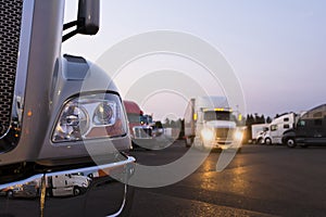 Fragment of modern semi truck on truck stop with lights