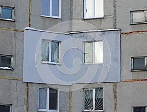 A fragment of a multi-storey concrete panel residential building with an externally applied external insulation on the