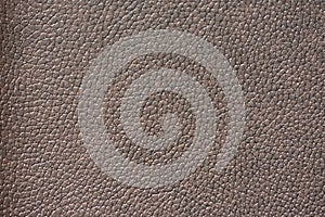 Fragment of natural brown leather with traces of polishing and a slight sheen close-up