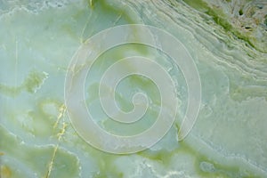 Fragment of natural polished Verde Onyx stone of green color with stains and streaks photo