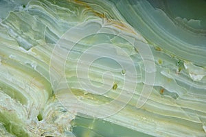 Fragment of natural polished Verde Onyx stone of green color with streaks photo