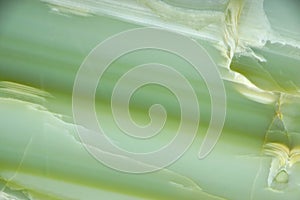 Fragment of natural polished Verde Onyx stone of green color with stripes and streaks photo