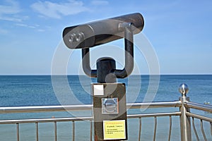 A fragment of observation binoculars against the background of the Baltic Sea. Zelenogradsk, Kaliningrad region. Russian text