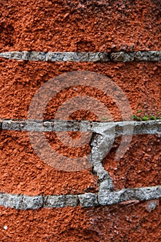 fragment of an old brick wall made of red brick and cement mortar
