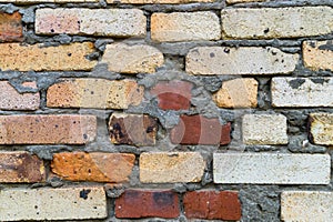 A fragment of an old brick wall in orange red and yellow colors.Texture, background.