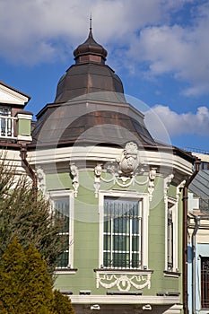 Fragment of an old building with a copper roof in the shape of a dome