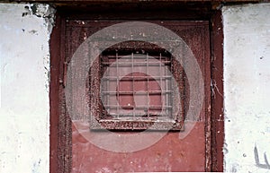 A fragment of an old door with a lattice window