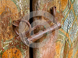 Fragment of an old door locked to a home-made castle in the stone house of the mountaineers of the Caucasus