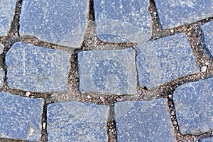 Fragment of an old granite pavement made of square blocks