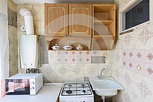 A fragment of an old kitchen set in the interior of a kitchen in need of repair