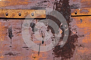 Fragment of old rusty iron gates with rivets.