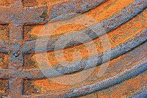 Fragment of an old rusty manhole cover. Closeup.