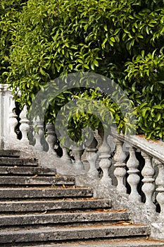 Fragment Old stone balustrade of railing background of green trees. Classic design and architecture. A picturesque