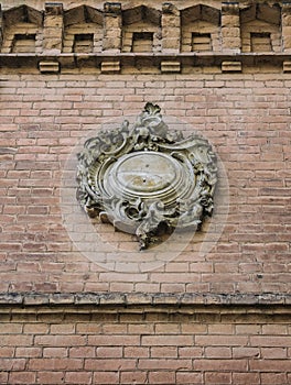 A fragment of the old wall with a floral Cartouche cartouch, detail of facade, architecture detail.