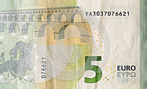 Fragment of one five euro money bill. Colorful details of European union currency banknote of five euro