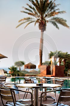 A fragment of an outdoor cafe by the pool in the first rays of the rising sun.