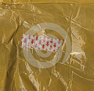 The fragment packing postage. brown paper completely glued with yellow tape. photo