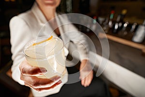 Fragment photo of delicious beverage in hand of bar visitor