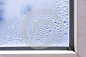 A fragment of a plastic window with condensation of water on the glass. Concept: defective plastic window with condensation,