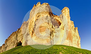 Fragment of the precipitous limestone rock against clear sky