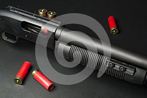 Fragment of a pump-action shotgun with cartridges on a black background.