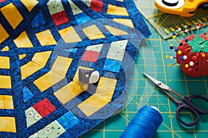 Fragment of a quilt, surrounded by tools for quilting