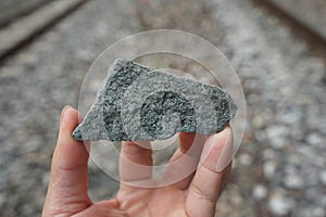 A fragment of raw granite rock on civil engineer's hand. Crush Stones Ballast.