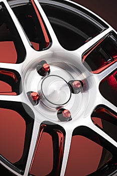 a fragment of red alloy wheels, spokes, wheel nuts and details of a sports car wheel close-up on a red background , a