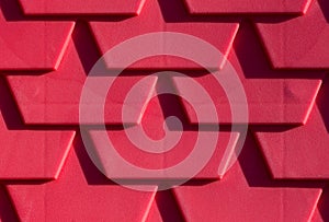 Fragment of red plastic shingles roof for background
