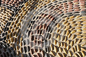 Fragment of reflexology cobblestones pathway for foot massage . Mosaic circle pattern from convex rounded pebble stones