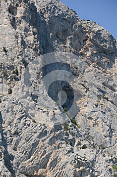 Fragment of a rocky mountain with a cave