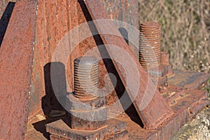Fragment of a rusty metal construction with bolts and nuts. A High-voltage power transmission tower. Power engineering
