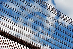 Fragment of security fence against blue sky