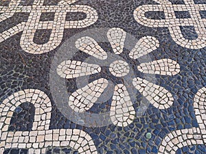 Fragment of sidewalk paving from polished, natural cobblestone blocks in Lisbon, Portugal. photo