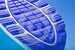 Fragment of the sole of a blue sneaker close-up. Textured texture of the material of sports shoes