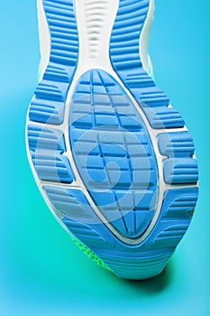 Fragment of the sole of a blue sneaker close-up. Textured texture of the material of sports shoes