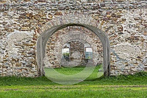 Fragment of stone old ruins overgrown with grass