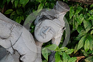 A fragment of a stone statue depicting the embittered face of a man