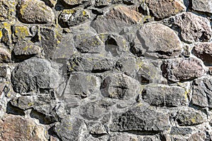 Fragment of the stone wall of the old castle as a natural background.