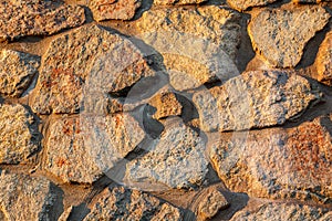 Fragment of sunlit stone wall