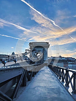 A fragment of the Szechenyi Chain Bridge over the Danube River in the early morning against a blue sky