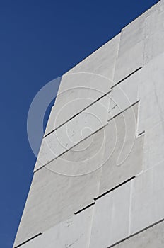 A fragment of a tall residential building against a clear blue sky