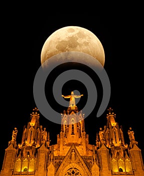 Fragment of the Temple of the Sacred Heart of Jesus at night with the moon on Mount Tibidabo. Barcelona, Spain